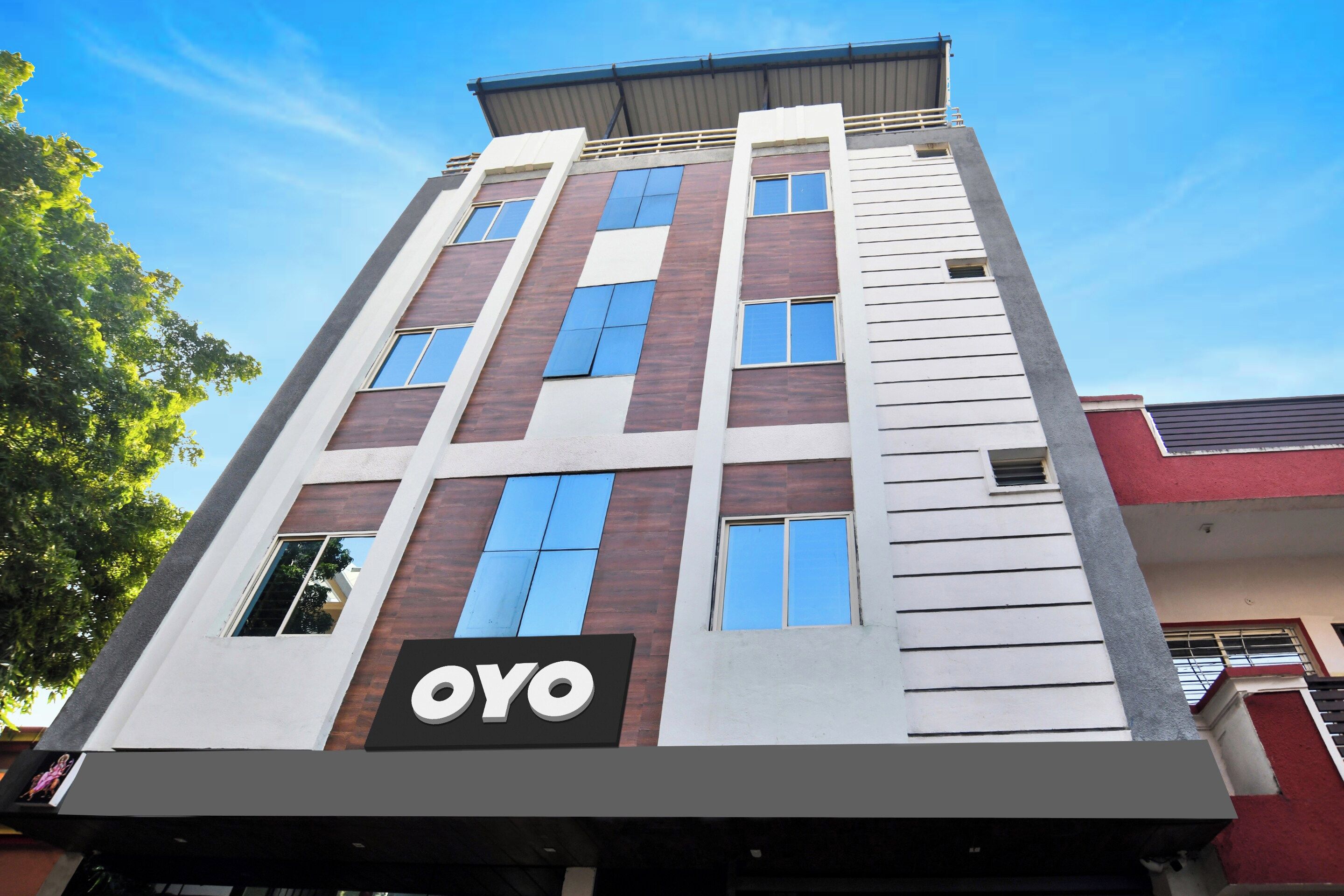 Un edificio de varios pisos con un llamativo letrero 'OYO' a nivel de calle.