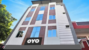Un edificio de varios pisos con un llamativo letrero 'OYO' a nivel de calle.