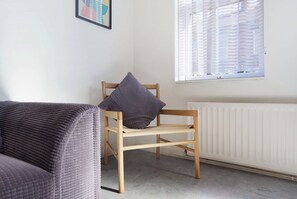 A room with a wooden chair, a cushion, a radiator, and a window with blinds. - Chic 1BR Stay near Darlington | Sleeps 2 | TV+WiFi (Darlington)