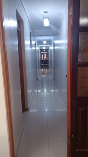 A corridor with a tiled floor and a door on the right.