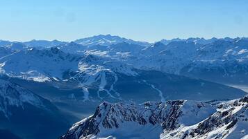 A mountainous landscape with snow-covered peaks and a valley.