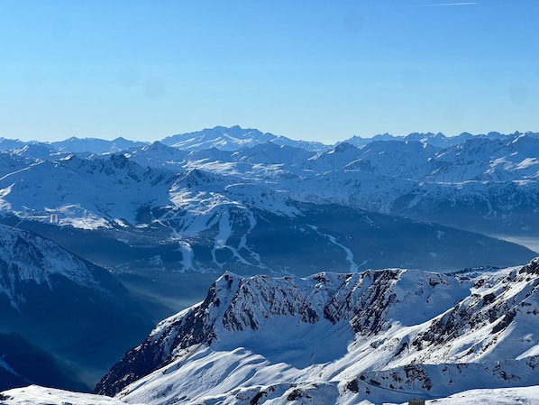 A mountainous landscape with snow-covered peaks and a valley.
