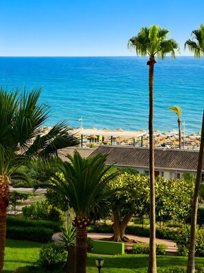 A coastal resort with a view of the sea, palm trees, and a building with a tiled roof. - Apartment 'La Canoa 79' with Sea Views, Wi-Fi and Air Conditioning (Torrox)