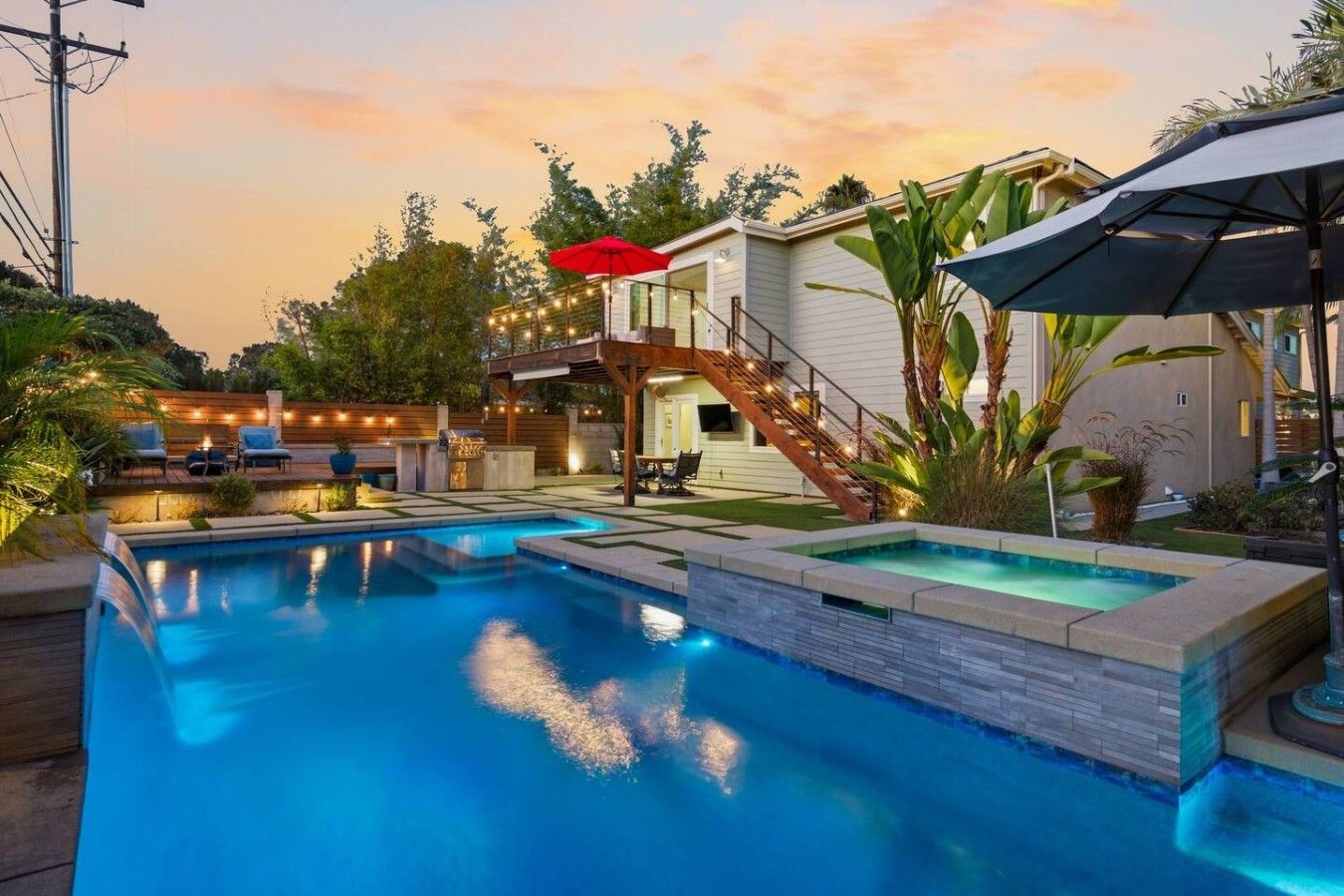 A swimming pool with a wooden deck and a covered seating area.