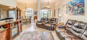 Ein geräumiges Wohnzimmer mit Ledersofas, einem Essbereich und einer Küche mit Holzschränken.