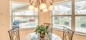 A conservatory with a glass ceiling, a dining table with chairs, and a potted plant. - Paradise Preserve - Single-story 3-bedroom home with a pool and screened lanai in Rotonda West (Rotonda West)