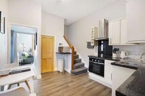 A modern kitchen with a built-in oven, microwave, and stainless steel range hood. - Serene 2BR Stay in Penrith | Sleeps 4+Parking+WiFi (Penrith)