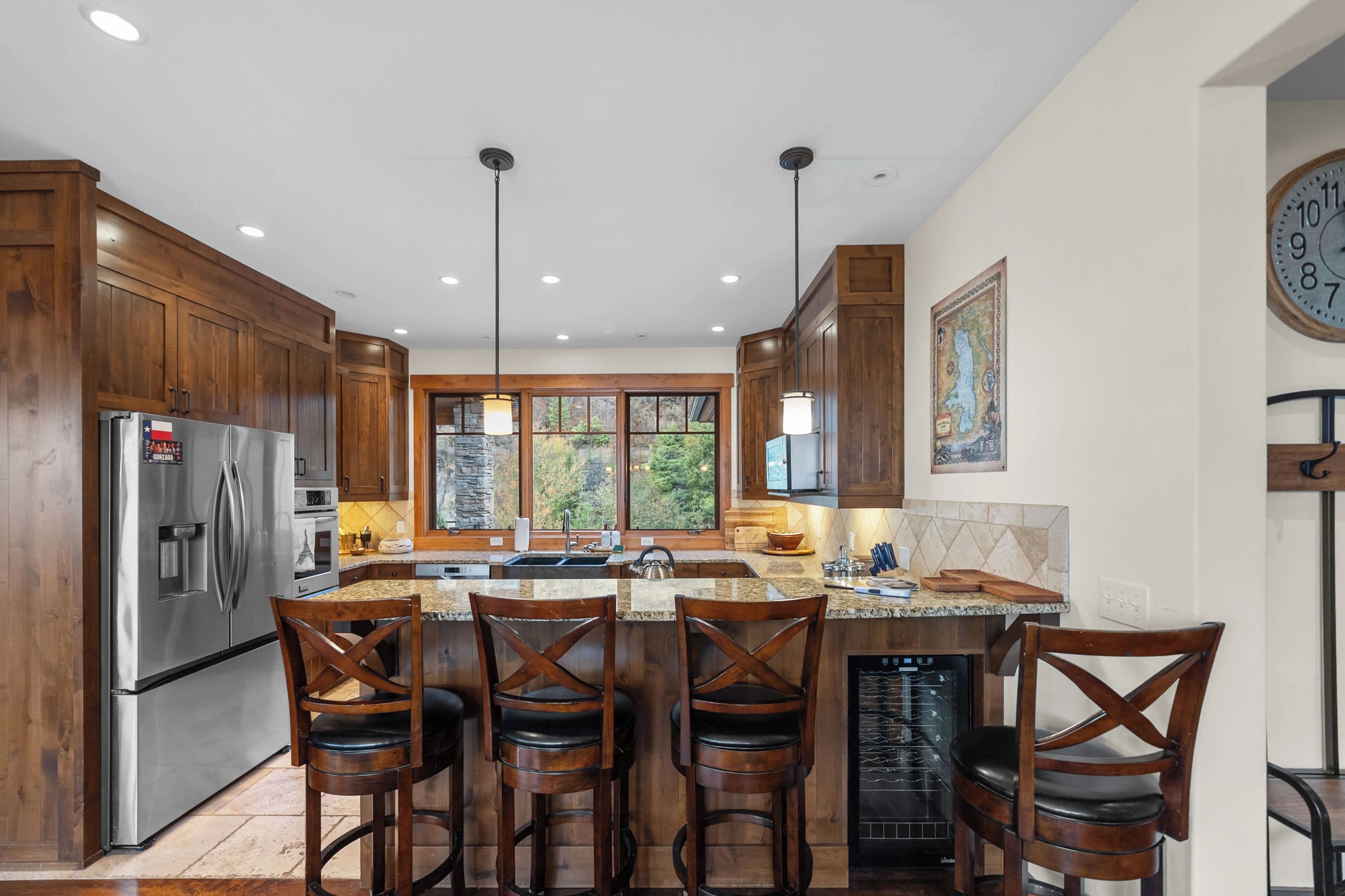 A modern kitchen with wooden cabinets, stainless steel appliances, and a central island with bar stools.