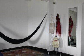 A room with a hammock, a hanging bag, and a mirror reflecting a patterned wall. - Holiday Home 'Noninha House' with Mountain View, Shared Terrace and Wi-Fi (Alvarenga)
