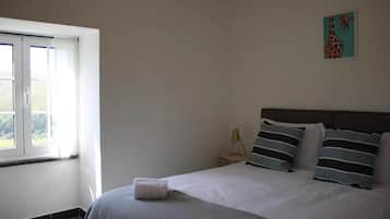 Un dormitorio con cama, ventana y un cuadro en la pared.
