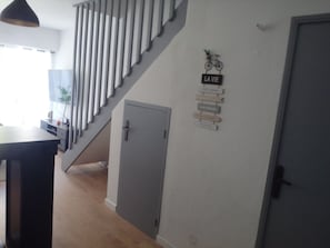 A staircase leading to a landing with a door and a wall-mounted sign. - New Listing (Nîmes)