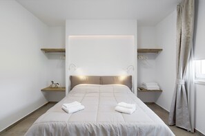 A modern hotel room with a large bed, bedside tables, and a headboard with integrated lighting. - Apartment 'Dama' with Private Terrace, Wi-Fi and Air Conditioning (Bardolino)