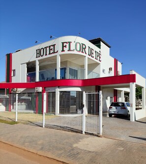 Een hotel met een opvallend bord waarop 'HOTEL FLOR DE IPE' staat.