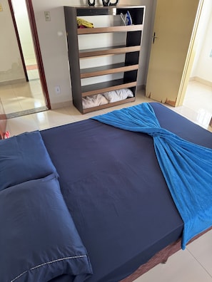 Habitació amb un llit, un armari i una porta.