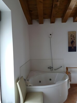A modern bathroom with a freestanding bathtub, a showerhead, and a handrail. - Country House 'Casa Rural La Antigua Fragua' (Los Llanos de Tormes)