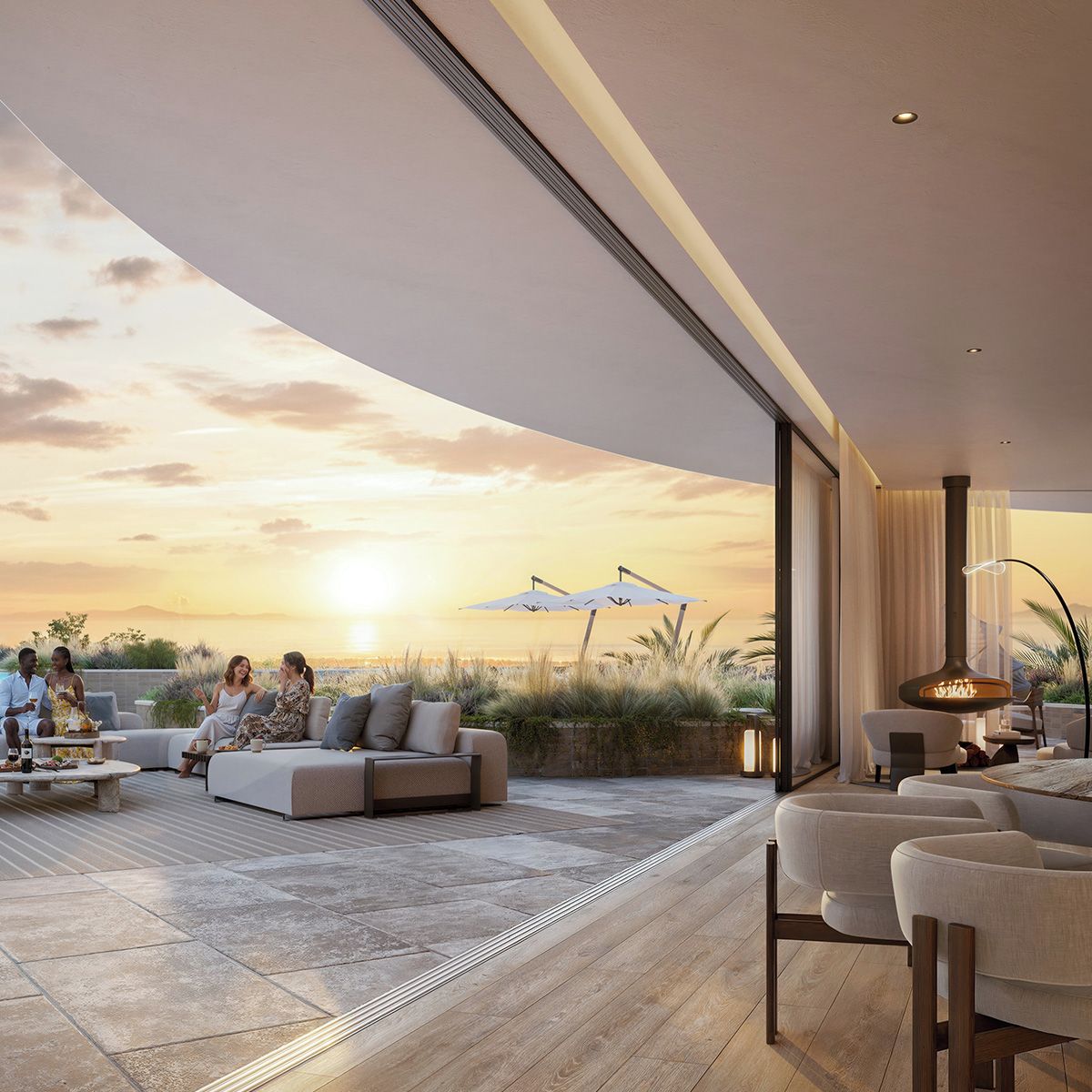 A modern outdoor seating area with a curved ceiling, a fireplace, and a view of the sunset.