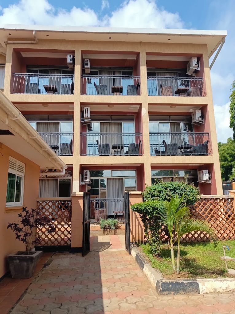 A multi-story building with balconies, air conditioning units, and a gated entrance.