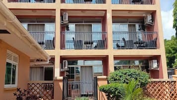 A multi-story building with balconies, air conditioning units, and a gated entrance.