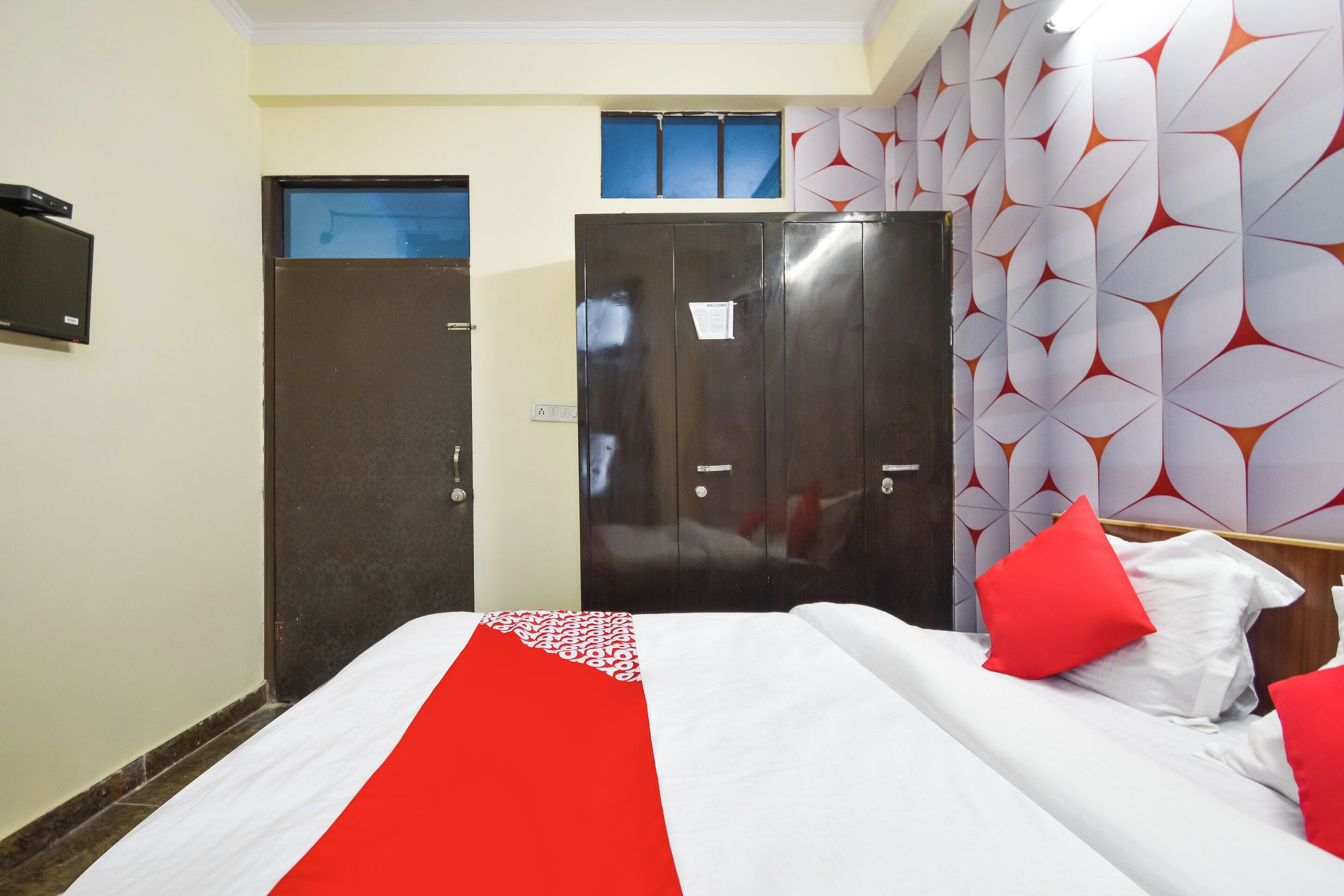 A hotel room with a bed, a wardrobe, and a door.