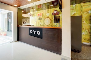 Ein Empfangsschalter mit einem Schild mit der Aufschrift 'OYO' und einer Uhr darüber.