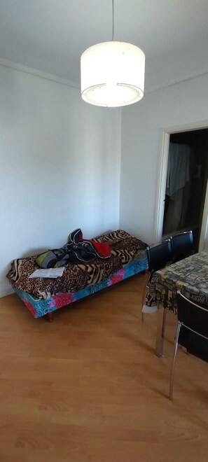Ein Zimmer mit einer Couch, einem Tisch und einer Hängelampe.