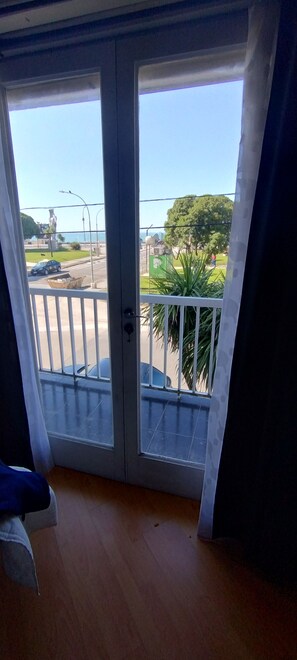 Ein Zimmer mit Blick auf einen Parkplatz und eine Grünfläche mit Bäumen.