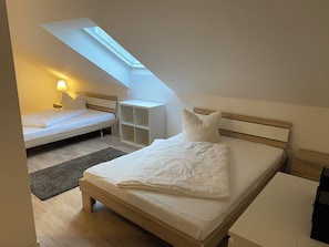 Een slaapkamer met dakraam, een bed, een nachtkastje en een bedtafel.