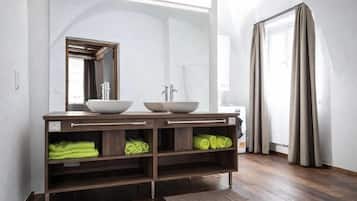 Un bagno con un mobile lavabo doppio, uno specchio e un porta asciugamani.