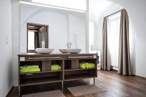 Un bagno con un mobile lavabo doppio, uno specchio e un porta asciugamani.
