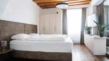 Una camera da letto con un letto, un armadio, una scrivania, una lampada e una finestra con tende.