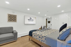 Een hotelkamer met een bed, een bank, een lijst en een spiegel.