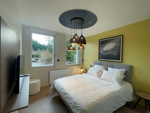 A bedroom with a bed, a window, a ceiling light fixture, and a wall-mounted artwork. - Ground-floor apartment in Niergnies - 2 guests (NIERGNIES)