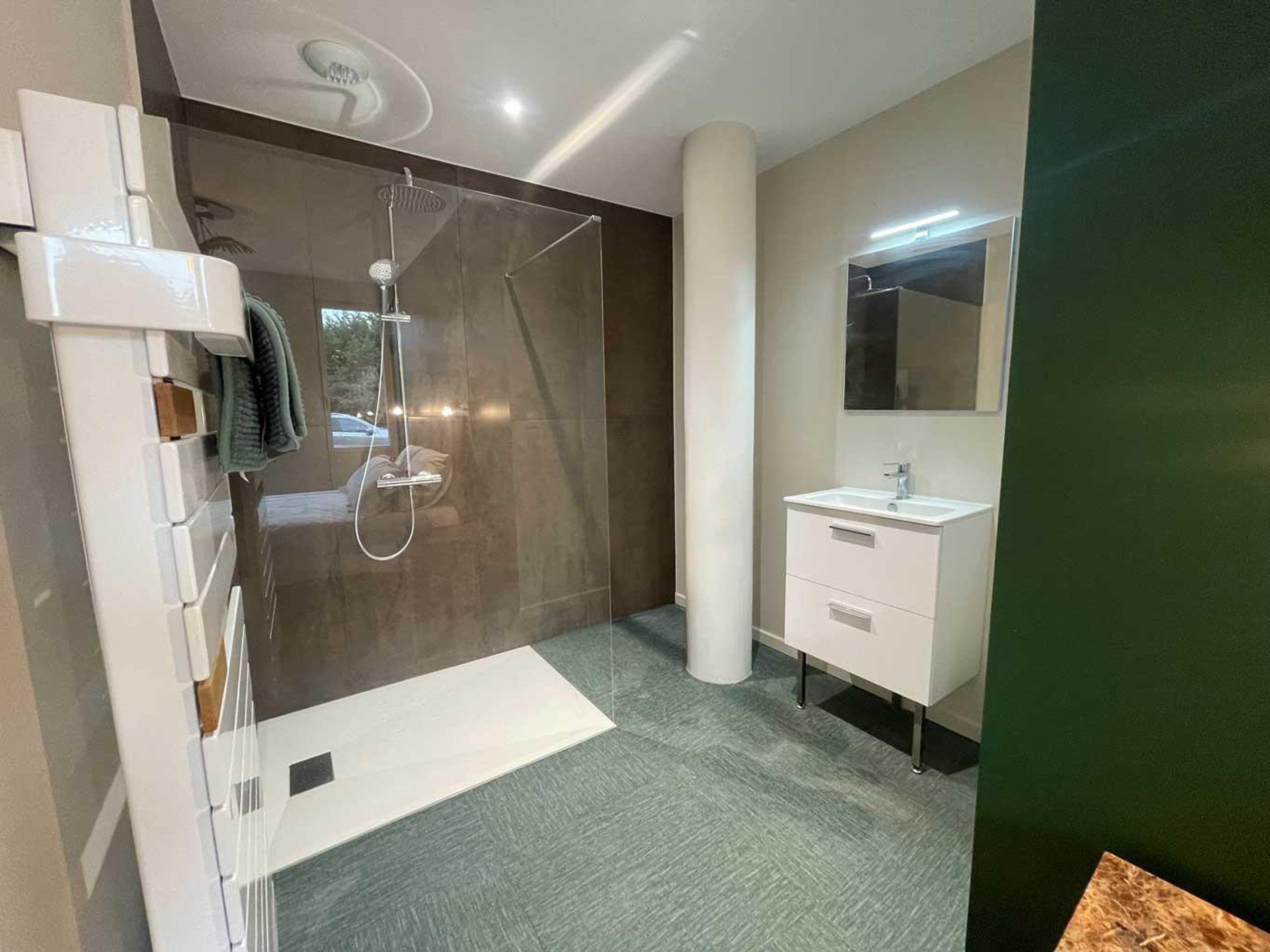 A modern bathroom with a shower, a sink, and a mirror.