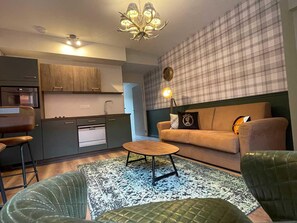 A modern living room with a sofa, a coffee table, and a patterned rug. - Modern and spacious apartment - 15 guests (NIERGNIES)