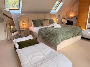 A modern bedroom with a large bed, a smaller bed, a desk, and a skylight. - The Scholars Nest Luxury Loft Gym Parking WiFi (Cambridge)