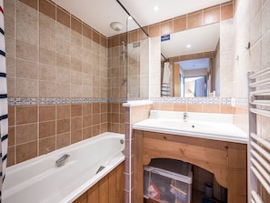 A bathroom with a bathtub, a sink, and a shower. - 3-room apartment mountain view - 6 guests (Le Corbier)