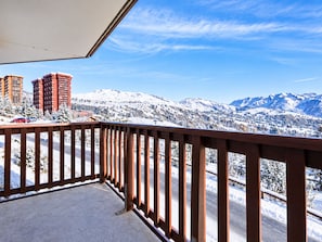 A balcony with a view of snow-covered mountains and buildings. - 3-room apartment mountain view - 6 guests (Le Corbier)
