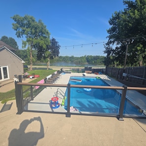 Ein Garten mit Pool, Liegestühlen und Seeblick.