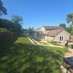 Ein Wohnhaus mit gepflegtem Rasen, Holzzaun und einer Garage.