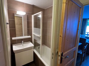 A bathroom with a shower enclosure, a sink, and a mirror. - Apartment with parking - 5 guests, Morillon (Morillon)