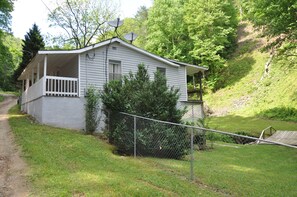 A small, single-story house with a porch and a fenced yard. - Whispering Cascade Creek-peaceful and romantic (Hot Springs)
