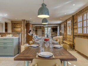 A dining area with a long wooden table set for a meal, surrounded by chairs. - Chalet at the foot of the slopes with sauna - 15 guests (Les Saisies)