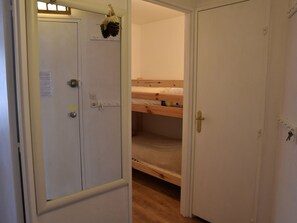 A room with a bunk bed, a door with a keyhole, and a hanging plant. - Central apartment - 6 guests (Montgenèvre)