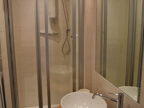 A modern bathroom with a glass-enclosed shower, a white sink, and a mirror. - Central apartment - 6 guests (Montgenèvre)