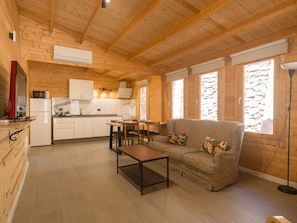 Un intérieur en bois comprenant une cuisine, un coin repas et un salon.