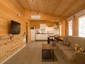 Un intérieur en bois comprenant une télévision, un coin cuisine et un espace salon.