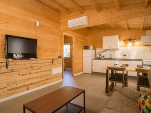 A wooden interior with a television, kitchen area, and seating. - Rural Refuge by CanariasGetaway (Telde)