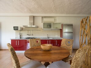 A kitchen with red cabinets, a microwave, a stove, and a refrigerator. - German Lofts by CanariasGetaway (Telde)