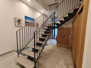 A modern staircase with metal railings and wooden steps leading to a landing. - Costa Suites 49 2D by CanariasGetaway (Las Palmas de Gran Canaria)