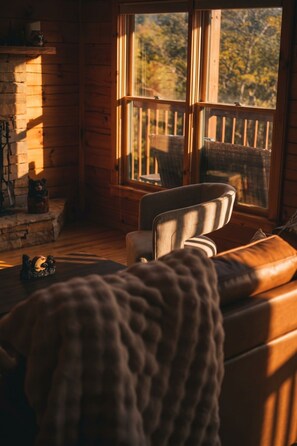 A cozy cabin interior with a wooden deck, a fireplace, and a comfortable seating area. - God`s Promise | Cozy, Peaceful, Hot Tub, Fireplace (Sevierville)